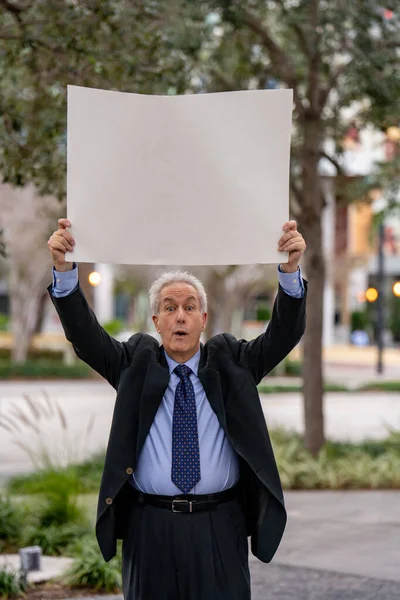 Протестующий Бизнесмен Держит Над Головой Чистый Белый Плакат — стоковое фото