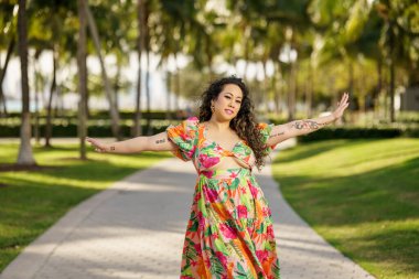 Kollarını açmış poz veriyor.