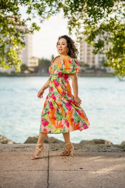 Omzunun üstünden bakıyor ve sırıtıyor.