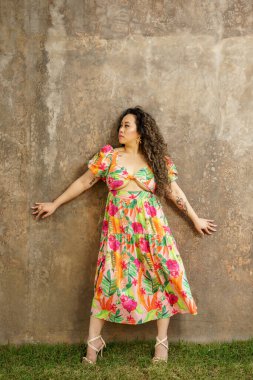 O, grunge beton arka planda poz veriyor.