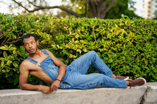 Foto Homem Vestindo Macacão Parque Ele Está Deitado Seu Lado — Fotografia de Stock