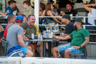 Fort Lauderdale, FL, ABD - 27 Mart 2022: Sahil kenarında içki içen erkek arkadaşlar