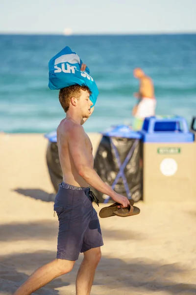 2022年3月27日アメリカ合衆国フロリダ州フォートローダーデール フォートローダーデールビーチの春のビーチで頭の上に袋を持って歩く若い男 — ストック写真