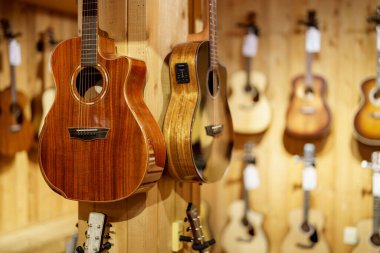 Guitars for sale hanging on a wall at a music store