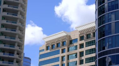  8k video highrise office buildings and slow moving clouds in city