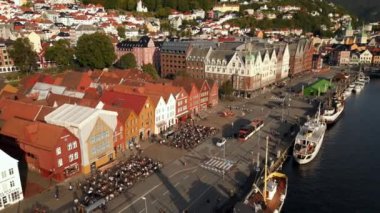 Bergen Norveç 'teki kafelerin önünde oturan turistler