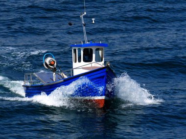 Small fishing boat underway at sea to fishing grounds. clipart