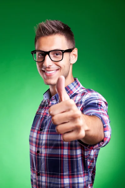 Mladý muž ukazuje palec nahoru gesto — Stock fotografie