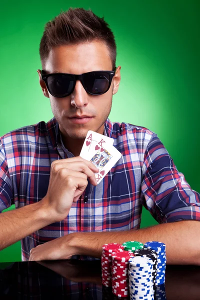 Joven jugador de poker mostrando un par de corazones altos — Foto de Stock