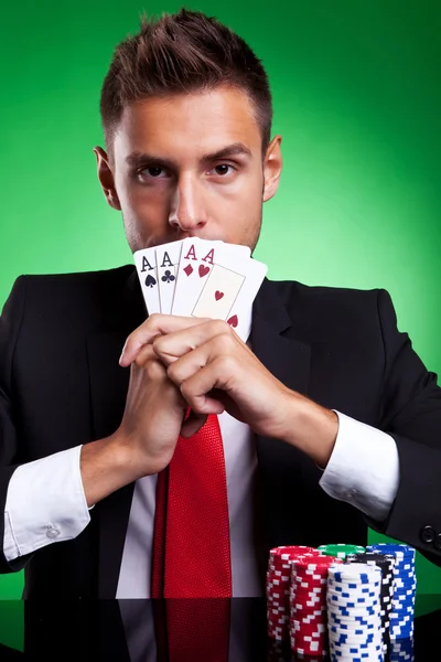 Jogador de cartas cobrindo sua boca com quatro ases — Fotografia de Stock
