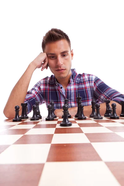 Young casual man thinking in front of the chessboard — Stock Photo, Image