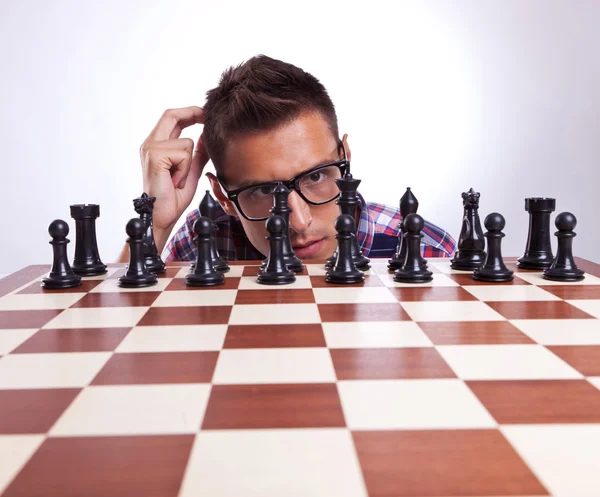 Pensive man in front of his first chess move — Stock Photo, Image