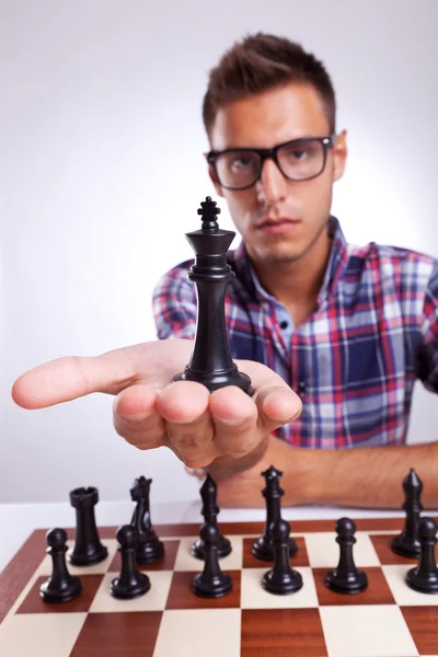 Young man chess player holding up his king — Stock Photo, Image