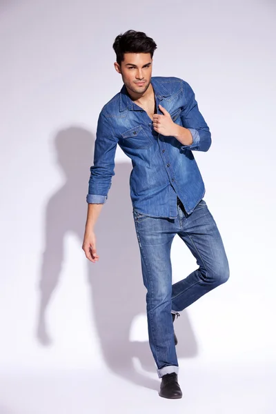 Мужчина, держащий джинсовую рубашку за воротник — стоковое фото