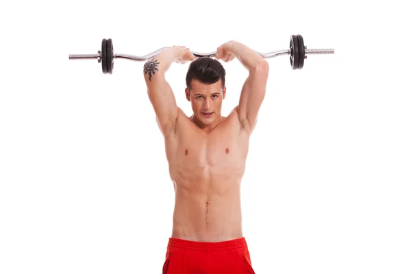 Young shirtless man lifting a barbell above head — Stock Photo, Image