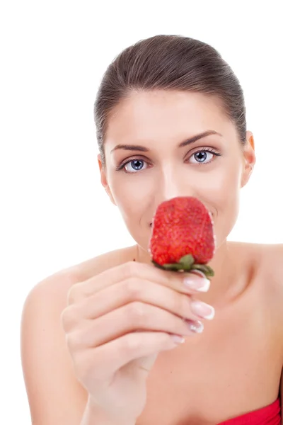 Junge Frau zeigt eine Erdbeere — Stockfoto