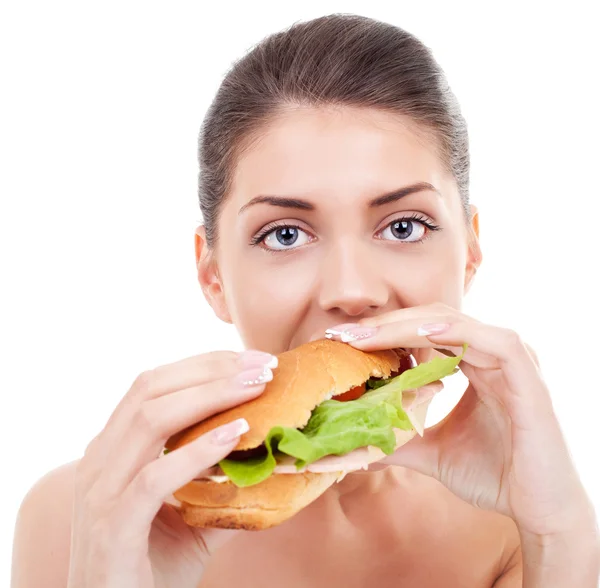 Junge Frau nimmt einen großen Bissen von einem Sandwich — Stockfoto