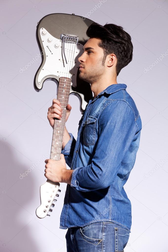 Young guitarist holding an electric guitar