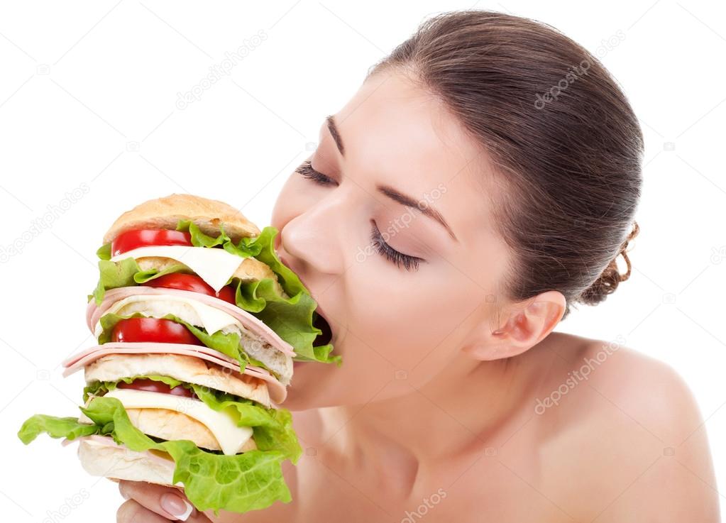 young woman biting a big sandwich