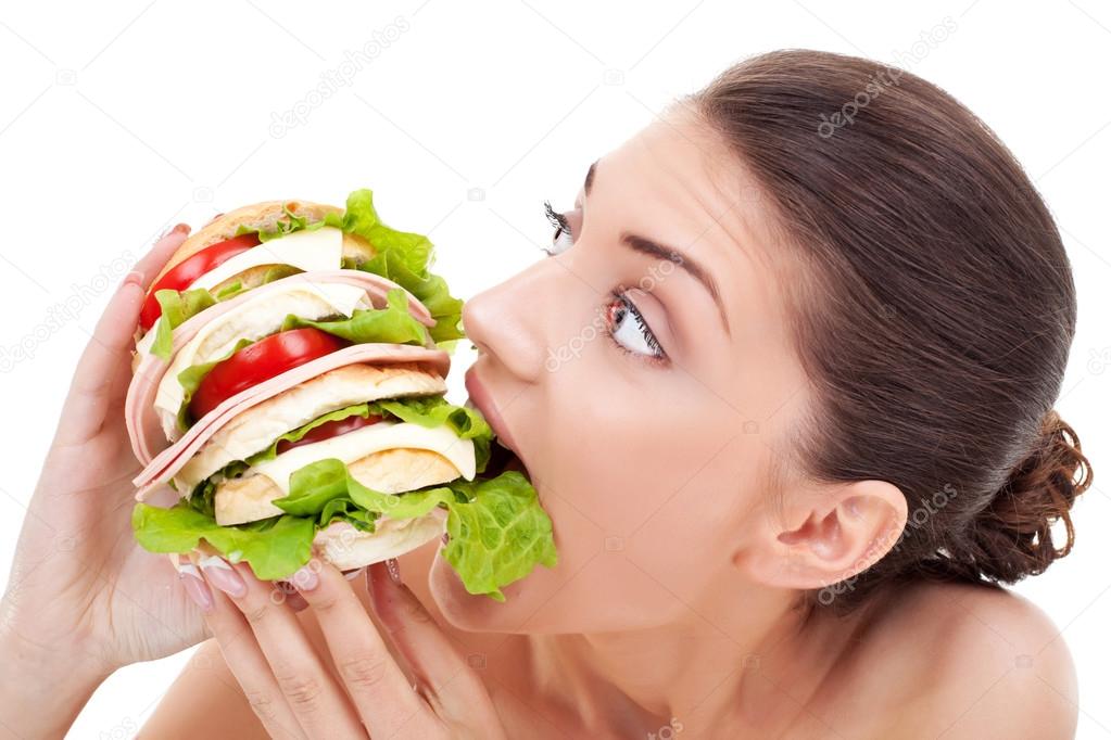 Young woman biting into a bread roll