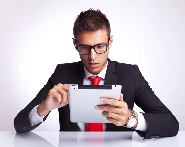 Hombre de negocios que selecciona algo en su almohadilla electrónica — Foto de Stock