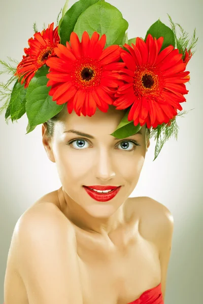 Gracefull mladá žena s červenými gerbera květy ve vlasech — Stock fotografie