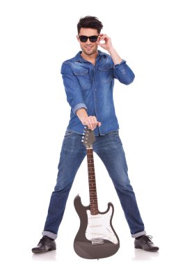 gitar bacaklarının arasında olan genç adam