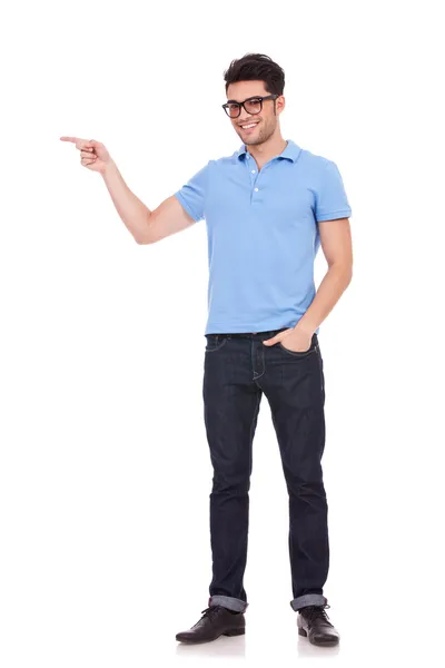 Young man pointing with a hand in pocket — Stock Photo, Image