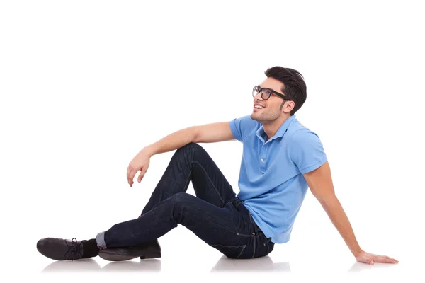 Junger Mann auf dem Boden schaut weg — Stockfoto