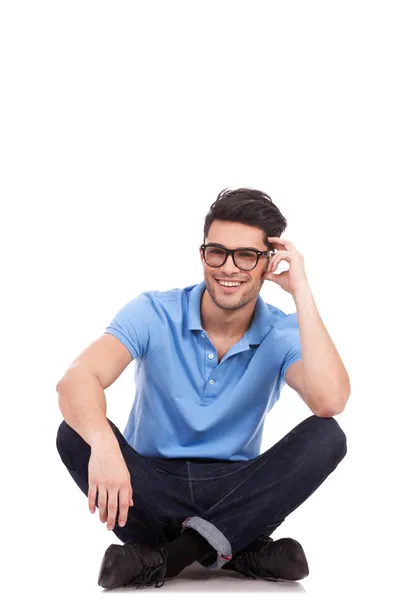 Young man holds head while sitting — Stock Photo, Image