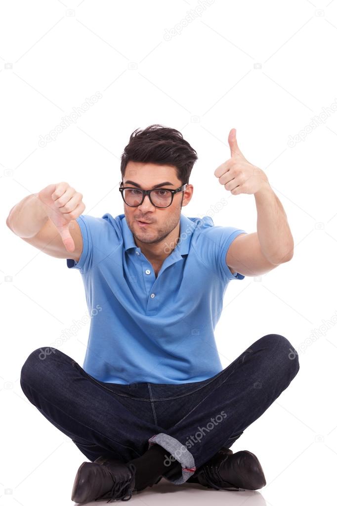 confused young man thumbs up and down