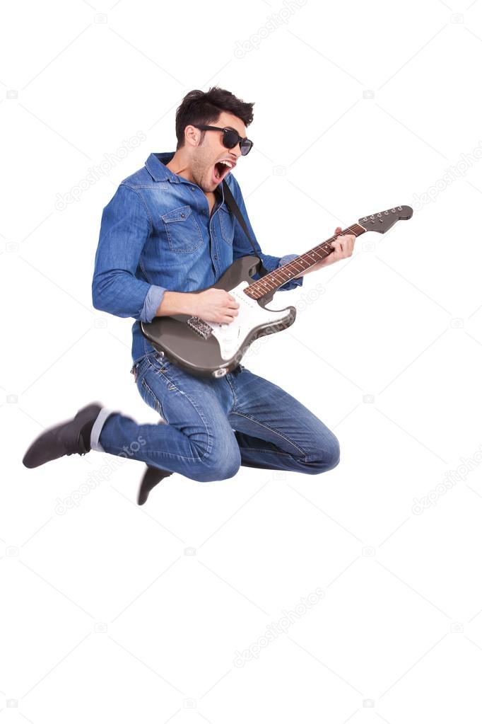 young man jumping with guitar