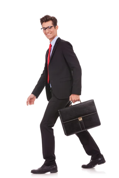 Business man holding a briefcase and walking — Stock Photo, Image