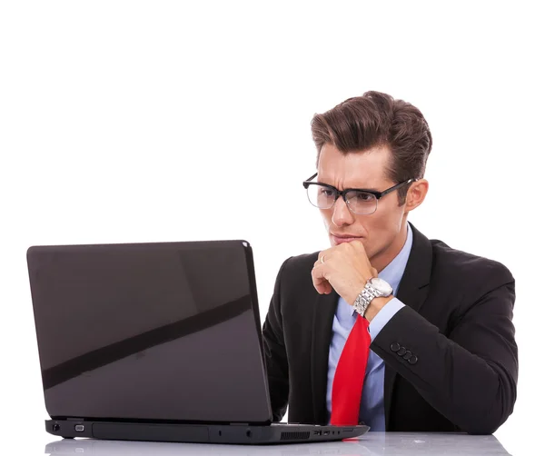 Young business man looking serious at laptop — Stock Photo, Image