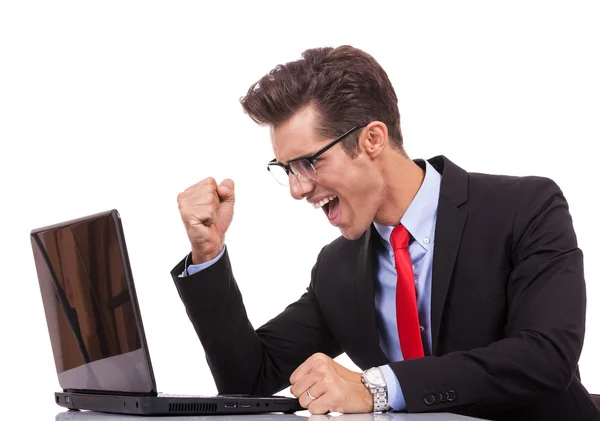 Feliz brazo levantamiento ganador hombre de negocios trabajando en su computadora portátil — Foto de Stock