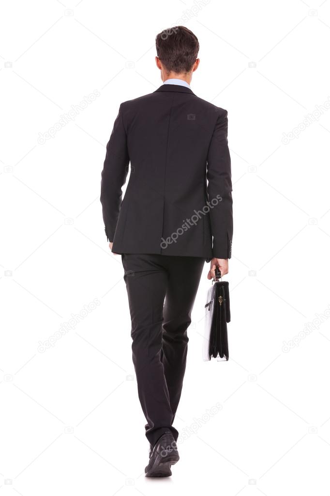 back view of a business man holding a briefcase and walking