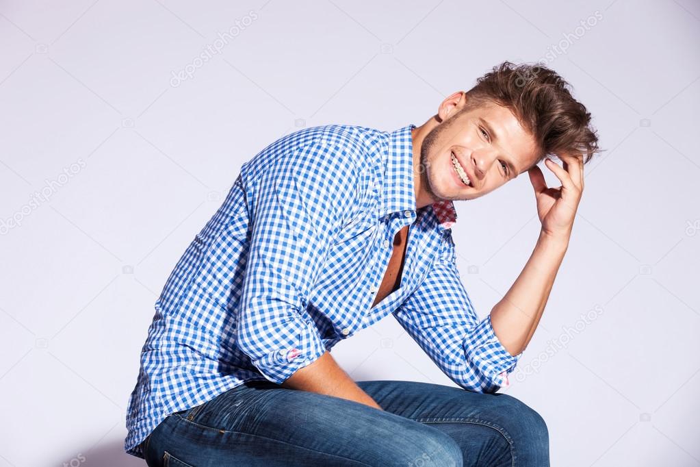 Fashion male model sitting and laughing
