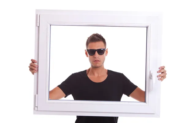 Hombre con gafas de sol está sosteniendo un marco de ventana de pvc — Foto de Stock