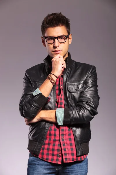Töprengő fiatal férfi bőrkabát és a szemüveg — Stock Fotó