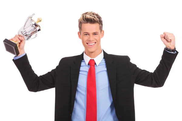 Homem de negócios segurando um troféu copo sobre branco — Fotografia de Stock