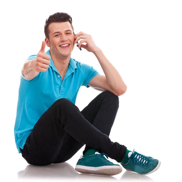 Seated man thumbs up on phone — Stock Photo, Image