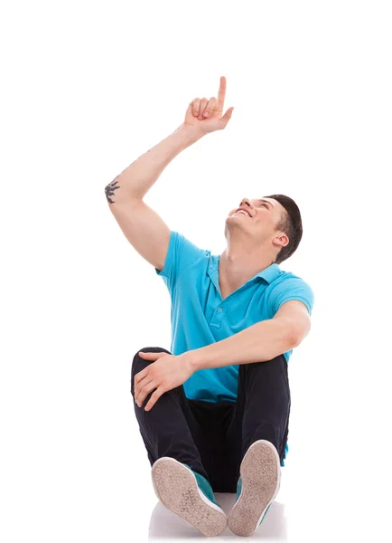 Seated man pointing and looking up — Stock Photo, Image