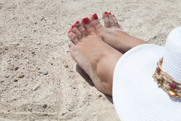 Rote genagelte Zehen einer Frau am Strand — Stockfoto