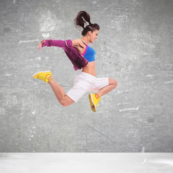 Zijaanzicht van een jonge vrouw danser springen — Stockfoto