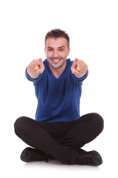 Lässiger Mann sitzt und zeigt — Stockfoto