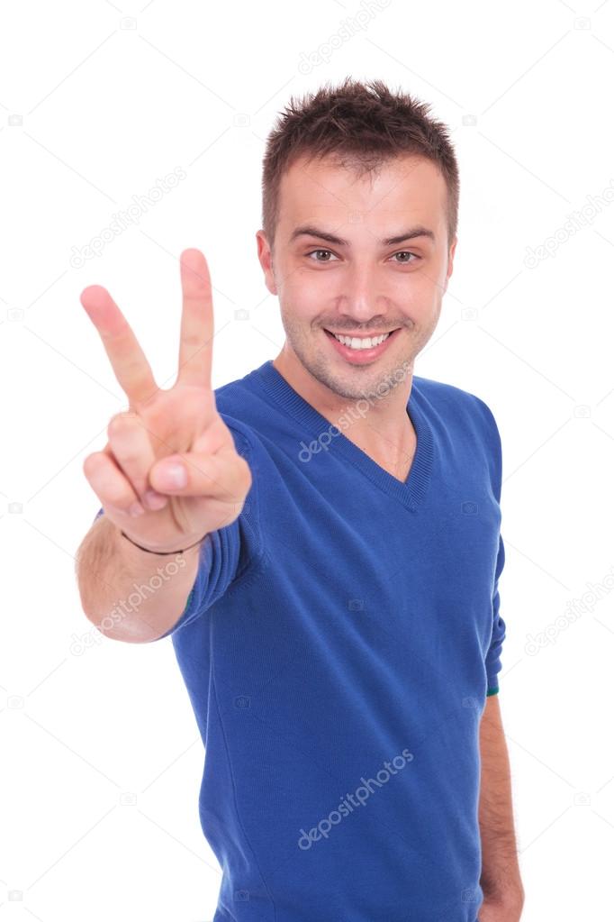 young casual man making victory sign