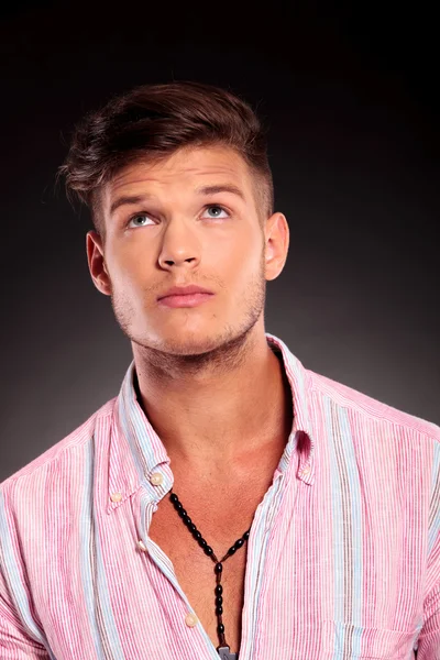 Genç adam yukarı bakıyor.