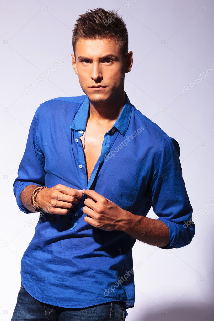 sexy man unbuttoning blue shirt