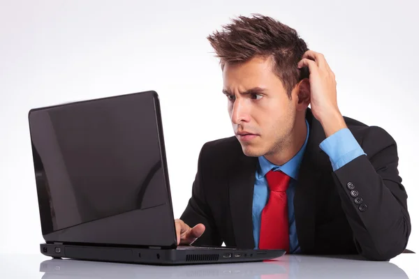 Confused man looks at laptop — Stock Photo, Image