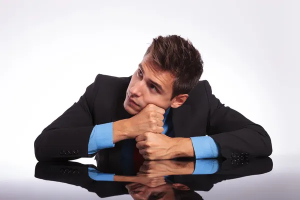 Homme rêveur assis au bureau — Photo